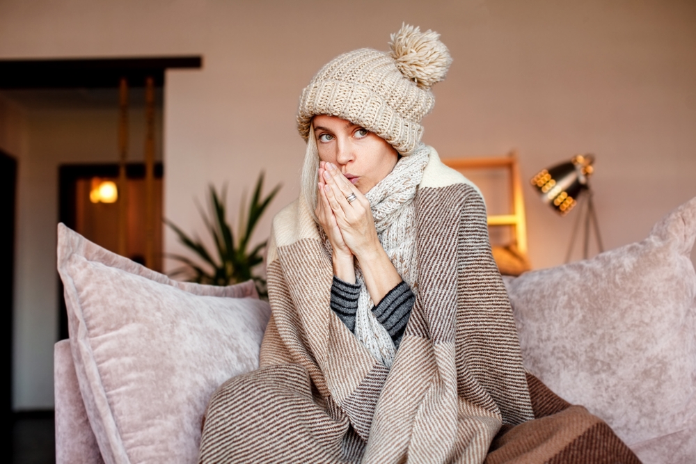 Woman,Warmly,Clothed,And,Hat,In,A,Cold,Home,Sitting